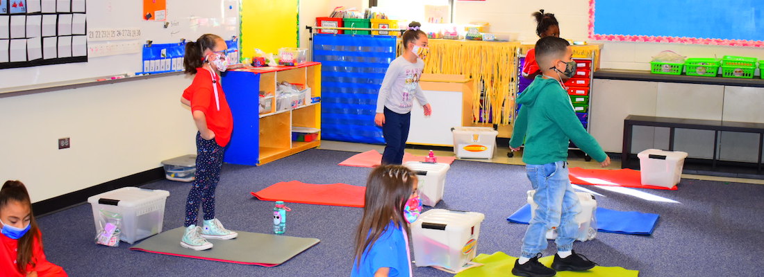 Students on mats in the classroom