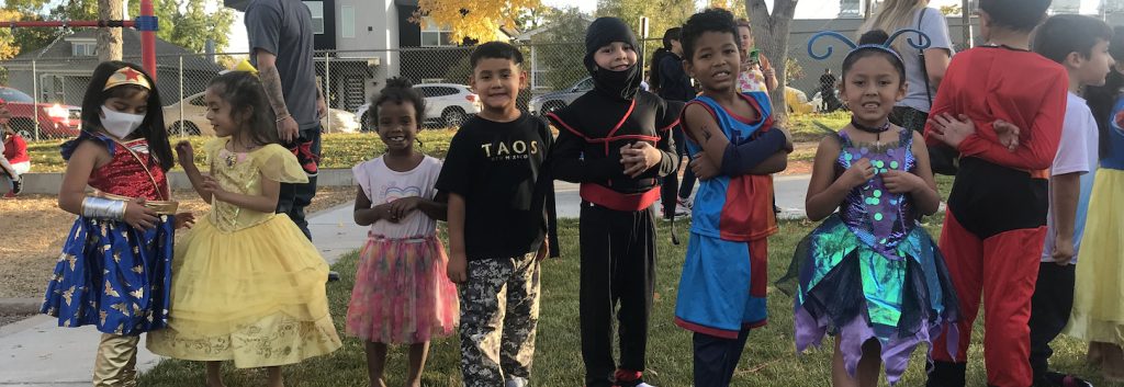 Group of students wearing costumes posing outside